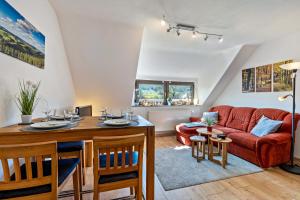 a living room with a red couch and a table at Ferienwohnung im Elsetal in Plettenberg