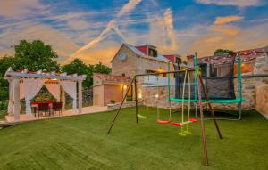 une aire de jeux dans l'arrière-cour d'une maison dans l'établissement Villa Kameni Cvijet - Makarska by Villas Guide, à Podbablje