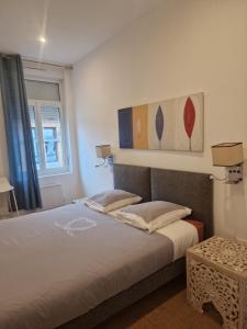a bedroom with a bed and a painting on the wall at APPART'HOTEL CASA Patricia in Béthune