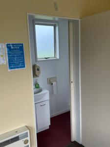 a small bathroom with a sink and a window at Green Hayes Estate Rentals - Green Hayes Cabin in Temuka