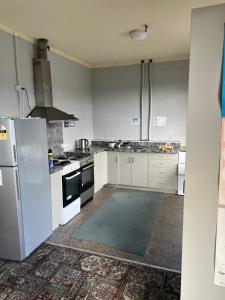 a large kitchen with white cabinets and appliances at Green Hayes Estate Rentals - Green Hayes Cabin in Temuka