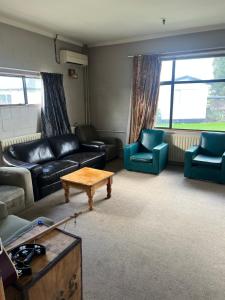 a living room with a couch and chairs and a table at Green Hayes Estate Rentals - Green Hayes Cabin in Temuka