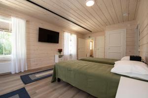 een slaapkamer met twee bedden en een flatscreen-tv bij Villa Ruuska 
