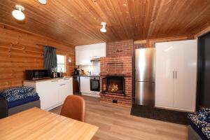 een keuken met een koelkast en een open haard bij Villa Ruuska 