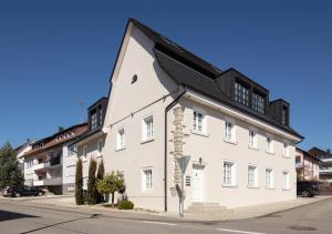 a white building with a black roof on a street at Seehaus Allensbach - Riviera Suite in Allensbach