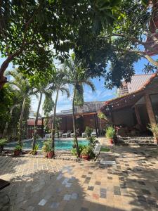 a resort with a swimming pool and palm trees at Ambedo Hotel Phu Quoc in Phu Quoc