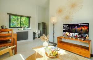 Una sala de estar con una mesa y una cocina. en Honey Moon House - Nature & Serenity - Near Aum Yoga - 4K SmartTV, en Ko Pha Ngan