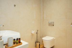a bathroom with a white toilet and a sink at Mely Luxury Apartments in Parga +10 photos