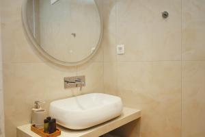 a bathroom with a white sink and a mirror at Mely Luxury Apartments in Parga
