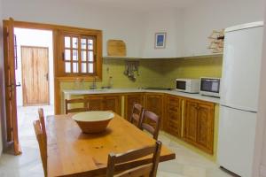 a kitchen with a wooden table and a white refrigerator at Casa Sol, Rodalquilar in Rodalquilar
