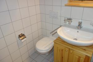 a white bathroom with a toilet and a sink at Pracondu 2 406 - OUTDOOR & FUN apartment 6 pers in Nendaz +7 photos