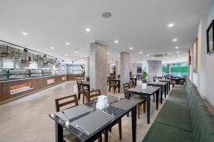 a restaurant with tables and chairs and a kitchen at Sun Heaven Queen in Alanya