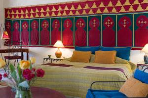 a bedroom with a bed with a red and green wall at Auberge Ksar Jallal in Ksar Oled Cherki