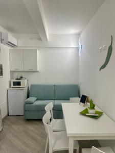 トロペアにあるChez-Nous Apartments by Bonsaiの青いソファとテーブルのあるリビングルーム