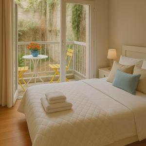 um quarto com uma grande cama branca com toalhas em Lovingly apartment Galatsi 1 em Atenas mais 4 fotografias