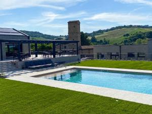 une piscine dans une cour avec un bâtiment dans l'établissement Maranello Resort Borgo Torre della Montina, à Maranello