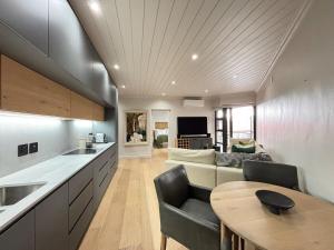 Una cocina y una sala de estar con un sofá y una mesa. en Modern living in central town, en Stellenbosch