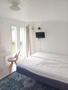 a bedroom with a bed and a desk and a window at Gladers väg 9 in Färjestaden