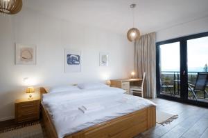 a bedroom with a bed and a desk and a window at TATRYSTAY Armeria Apartments in Štrbské Pleso