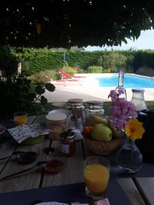 a table with a bowl of fruit and a vase of flowers at Thérouanne en Berry in Plaimpied-Givaudins