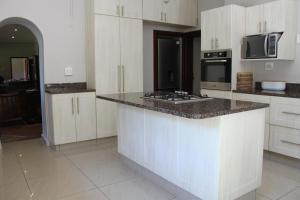 a kitchen with white cabinets and a counter top at The Old Barracks Boutique Guesthouse in Bathurst