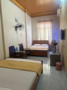 a hotel room with two beds and a couch at Nhà nghỉ Dung Hoà in Ha Long