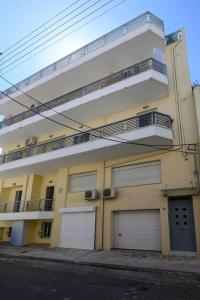 a building with two garage doors and two balconies at Myrto lower ground floor studio in Kalamata
