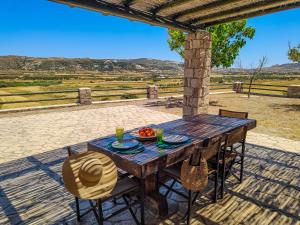 a wooden table with a bowl of fruit on it at Maravites Cottage in Zefiría