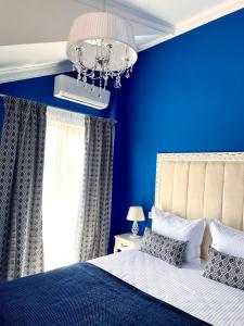 - une chambre bleue avec un lit et un lustre dans l'établissement REGINA Bed&Wine, à Varna 46 autres photos