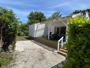 a small white cottage with a porch and a patio at Bungal'eau in Sciez