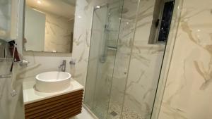 a bathroom with a sink and a glass shower at Lake Drive Rooms&Apartments in Tirana