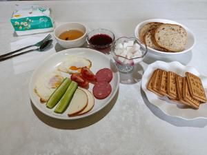 a table with a plate of food with bread and vegetables at Guest House Turna in Arkit