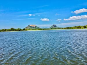 a view of the water with mountains in the background at Royal Breeze Resort Sigiriya in Sigiriya