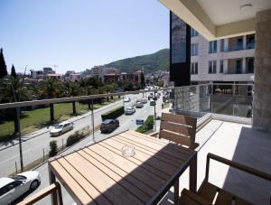 a balcony with a table and chairs and a street at Alpesa Apartments in Budva