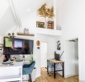 a living room with a desk and a tv at Premium Suite - Waldblick - Balkon - Schwarzwald in Bühl +14 photos