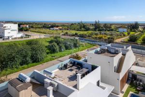 una vista aerea di una casa bianca con l'oceano sullo sfondo di Mira Luz - Luz de Tavira a Luz de Tavira