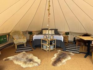 un letto in una tenda con due tappeti in una stanza di Glamping Tent with amazing view in the forest a Torsby