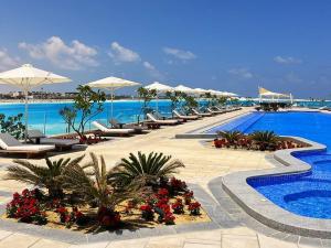 a resort with a swimming pool with chairs and umbrellas at Marassi luxury suites , the Address Resort , North coast in El Alamein