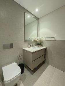 a bathroom with a toilet and a sink with a mirror at Nasma Luxury Stays - Chic HighRise 1 BR in the Heart of Dubai in Dubai +41 photos