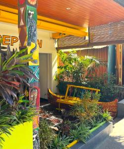a yellow bench sitting outside of a building with plants at VaoVao Hotel in Nosy Be