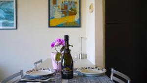 a table with a bottle of wine and a vase with flowers at Ciceri Properties Bertarello in Baveno