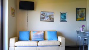 a living room with a white couch with blue pillows at Ciceri Properties Bertarello in Baveno