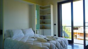 a white bed in a room with a large window at Ciceri Properties Bertarello in Baveno