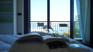 a book laying on a bed in front of a window at Ciceri Properties Bertarello in Baveno