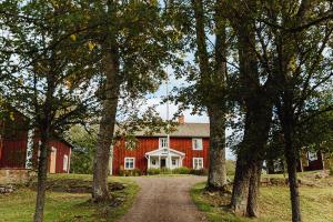a red barn with a dirt road in front at Åsens By in Haurida