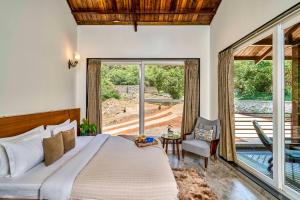 une chambre avec un lit et une grande fenêtre dans l'établissement SaffronStays Blissfort, à Malavli