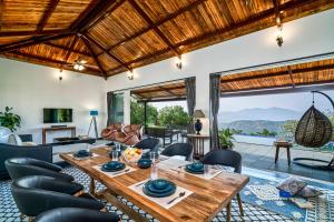 un salon avec une table et des chaises en bois dans l'établissement SaffronStays Blissfort, à Malavli