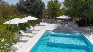 a swimming pool with lounge chairs and umbrellas next to a pool at Casa das Ameixas in Moncarapacho