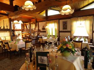 a dining room with tables with flowers and wine bottles at Hotel Landhaus Silbertanne in Rotenburg an der Fulda