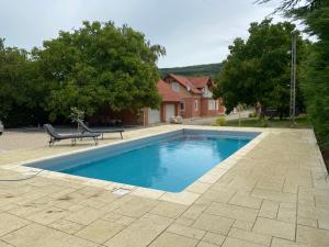 a swimming pool with a bench next to a house at Bikeaway Guesthouse in Kereki